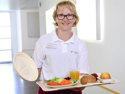 Serviceassistentin bringt Essen